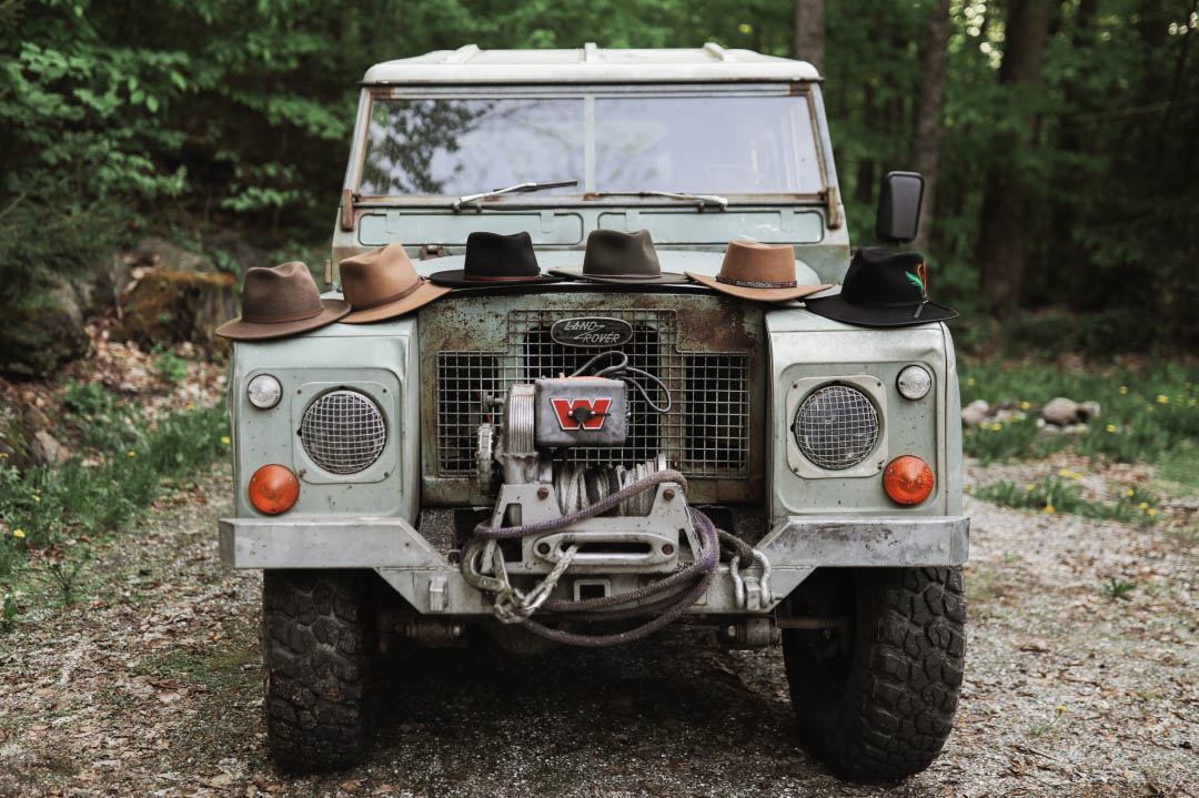 Stetson hats lined up on vintage Land Rover.